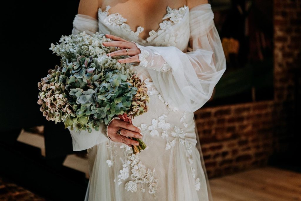Close up of bouquet and wedding dress sleeves